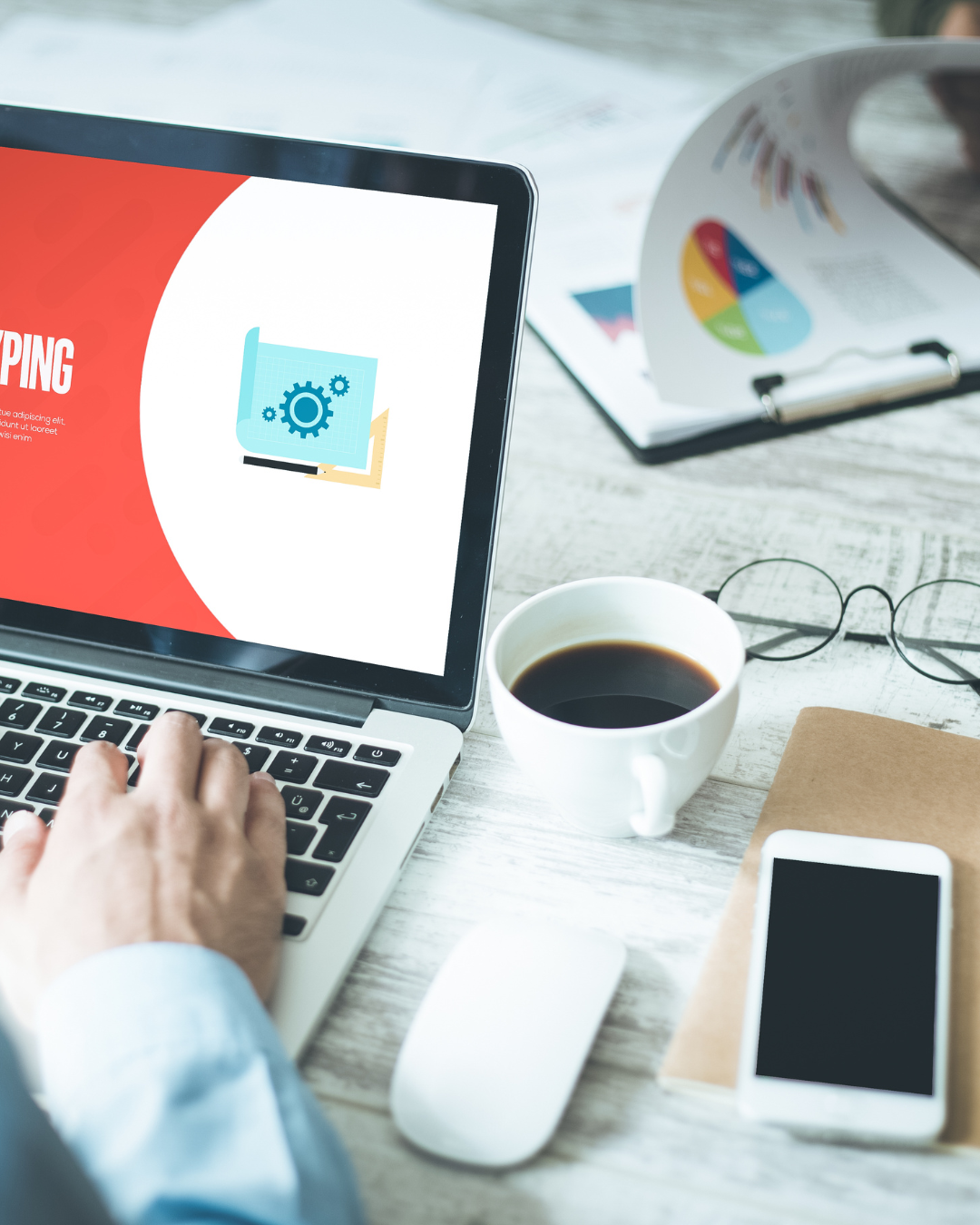 Laptop on desk with coffee and design work